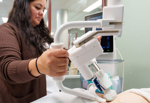 Remote Presence Nurse Clinician Brittany Olson guides the MELODY robotic ultrasonography system to examine a patient during a live technology demonstration.