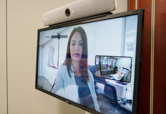 VHH Robotic Ultrasound Technologist Martine Pringle communicates with the patient-side clinician via video conferencing as part of a technology demonstration.